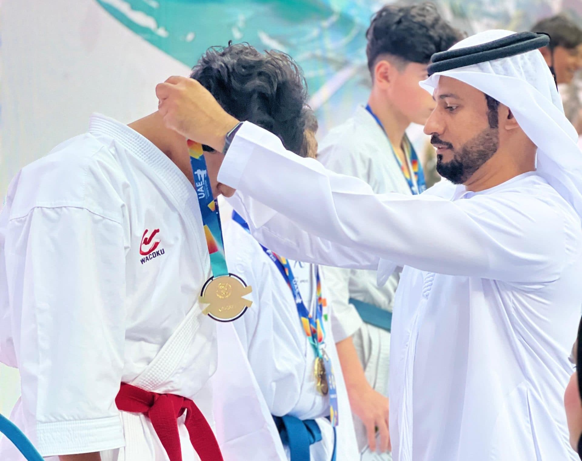 A Karate Pro student in white gi receiving a medal at a ceremony