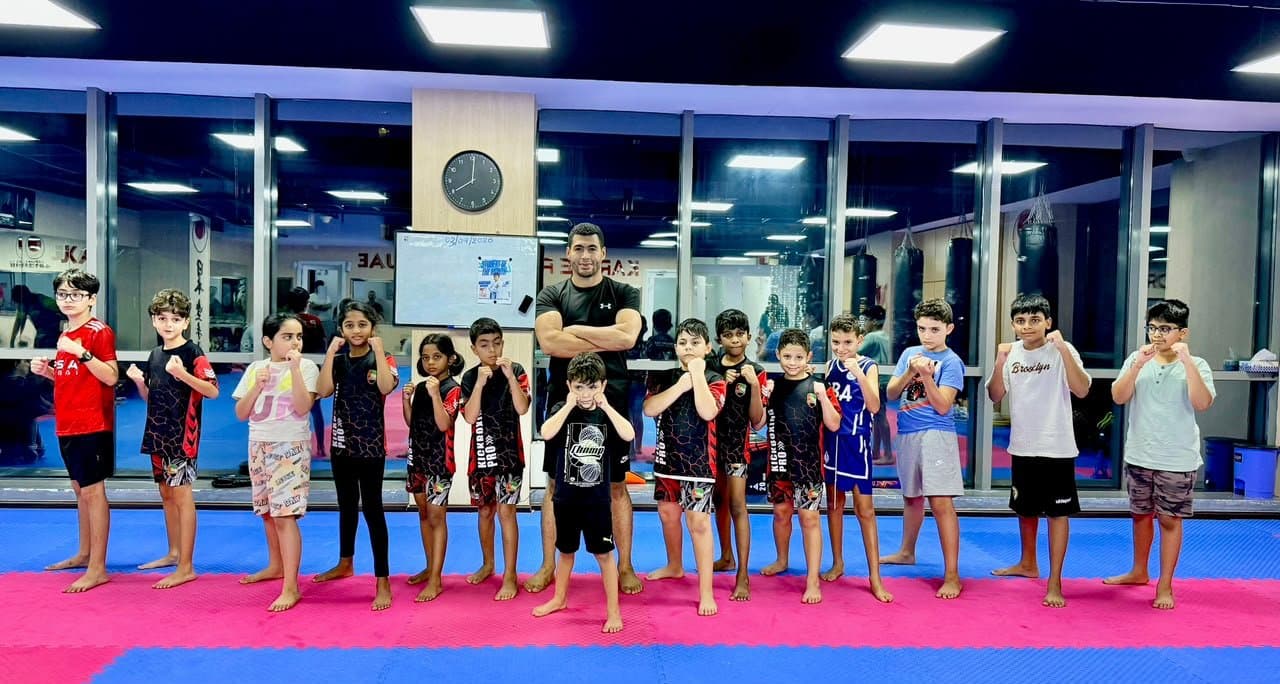 Coach posing with a line of young kickboxing students in a separate class photo