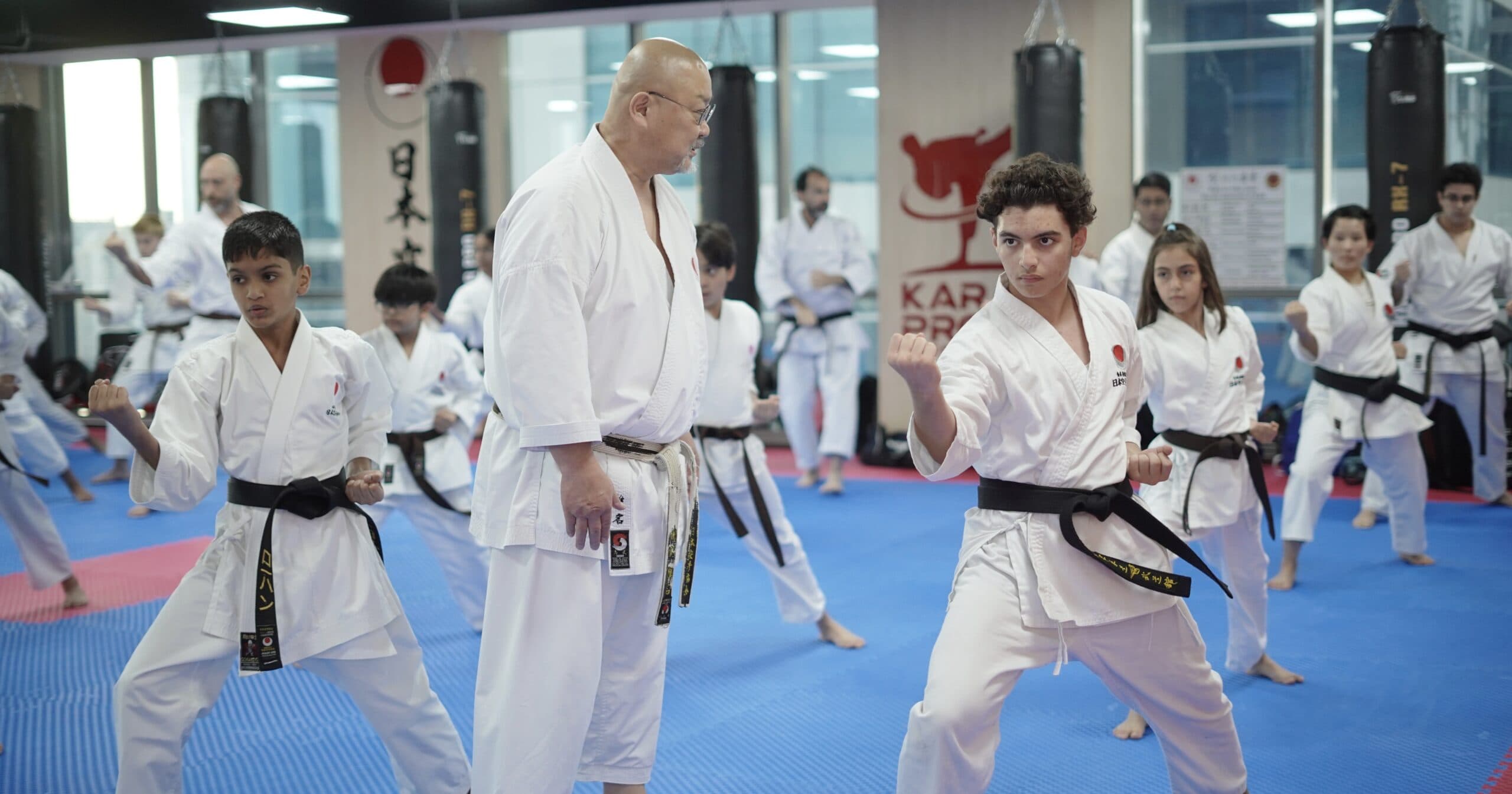 Children and teenagers performing kata together in a Karate Pro class