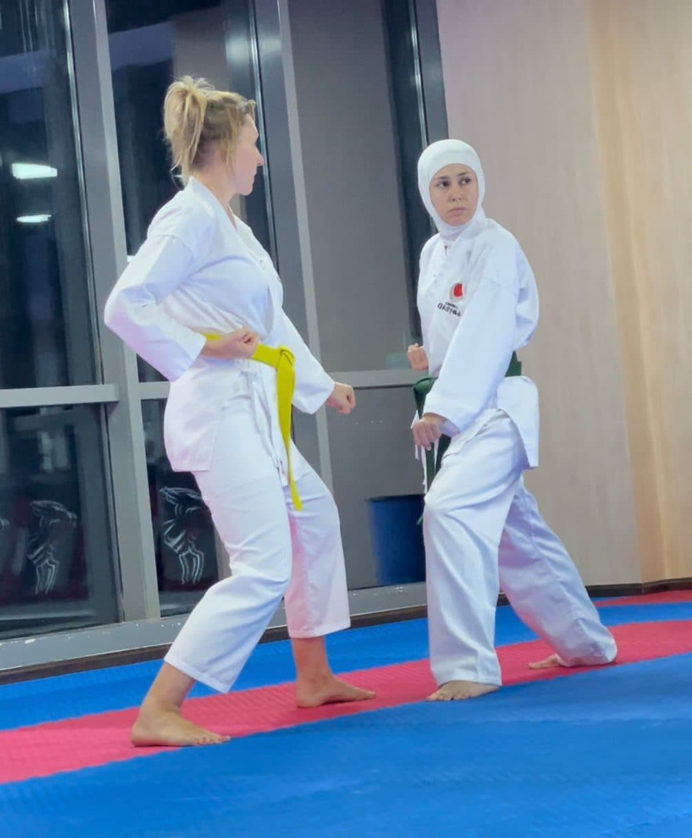 Two women in white gi training in a ladies-only karate class