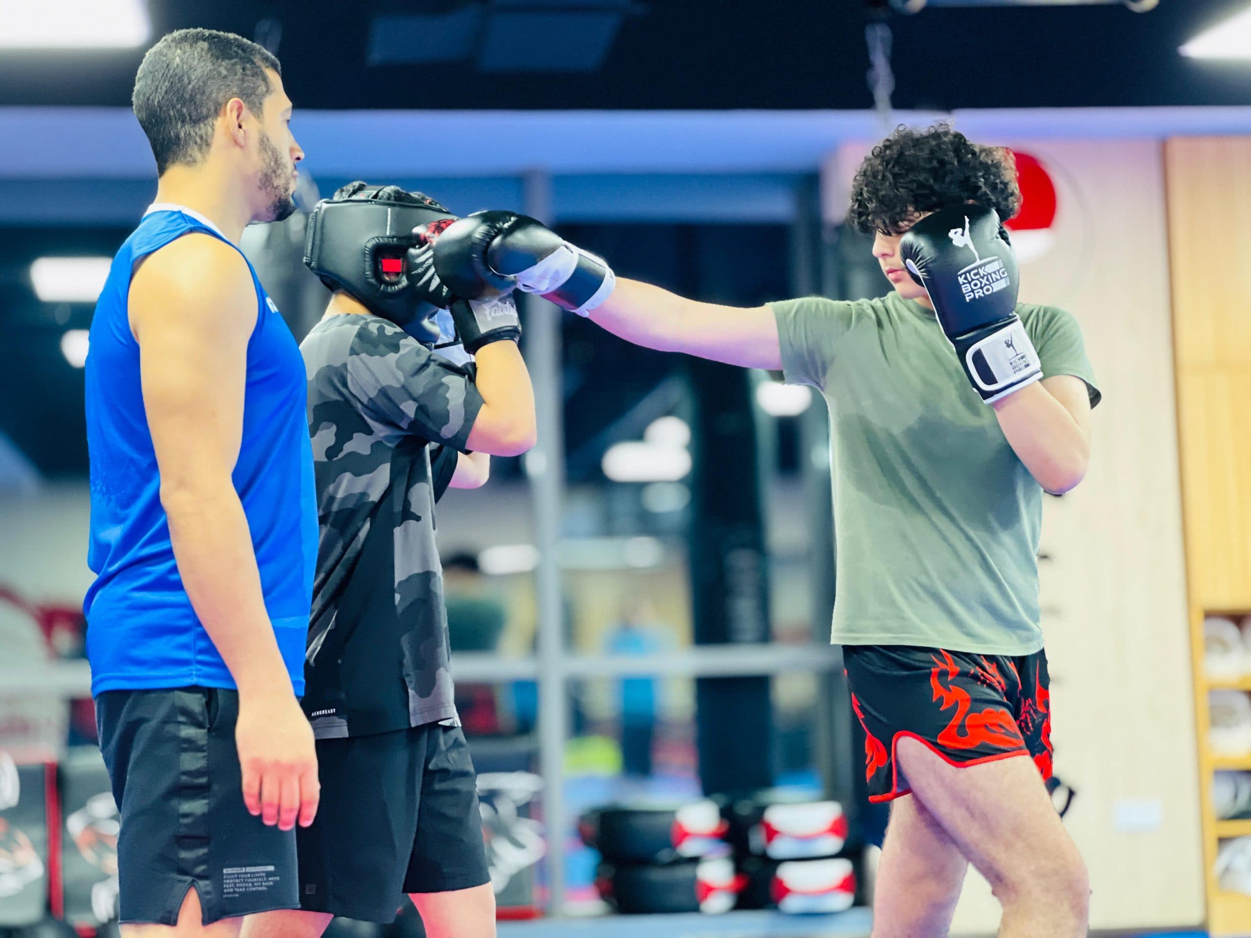 Kickboxing students training strikes on pads in the dojo