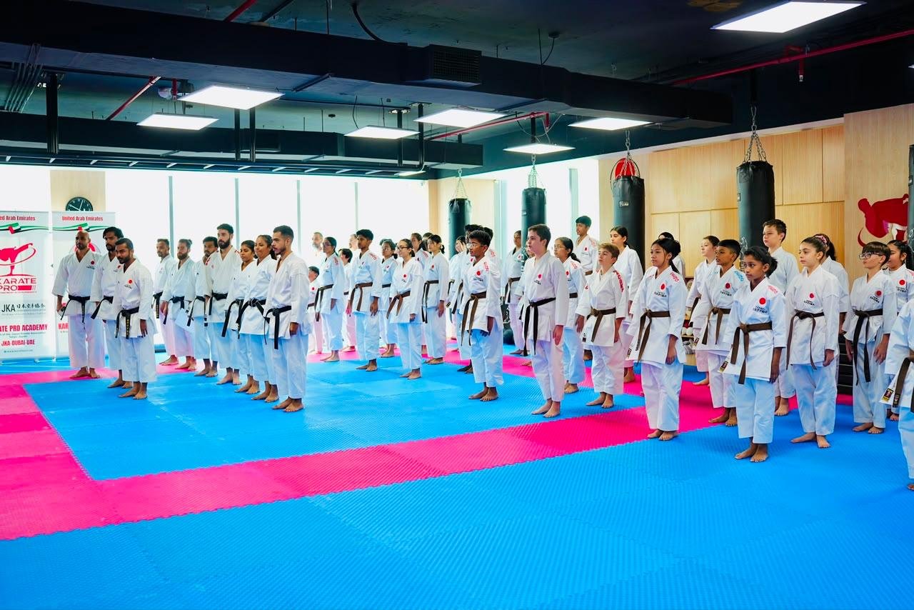 Karate class standing at attention in neat rows across the dojo mats