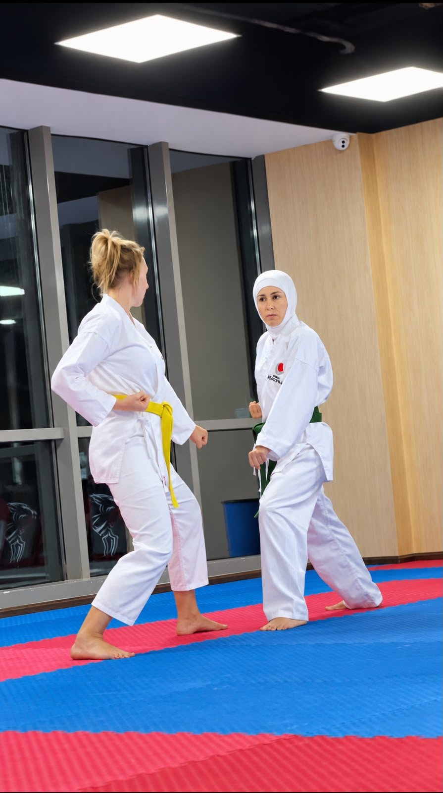 Two women in white gi training in a ladies-only karate class