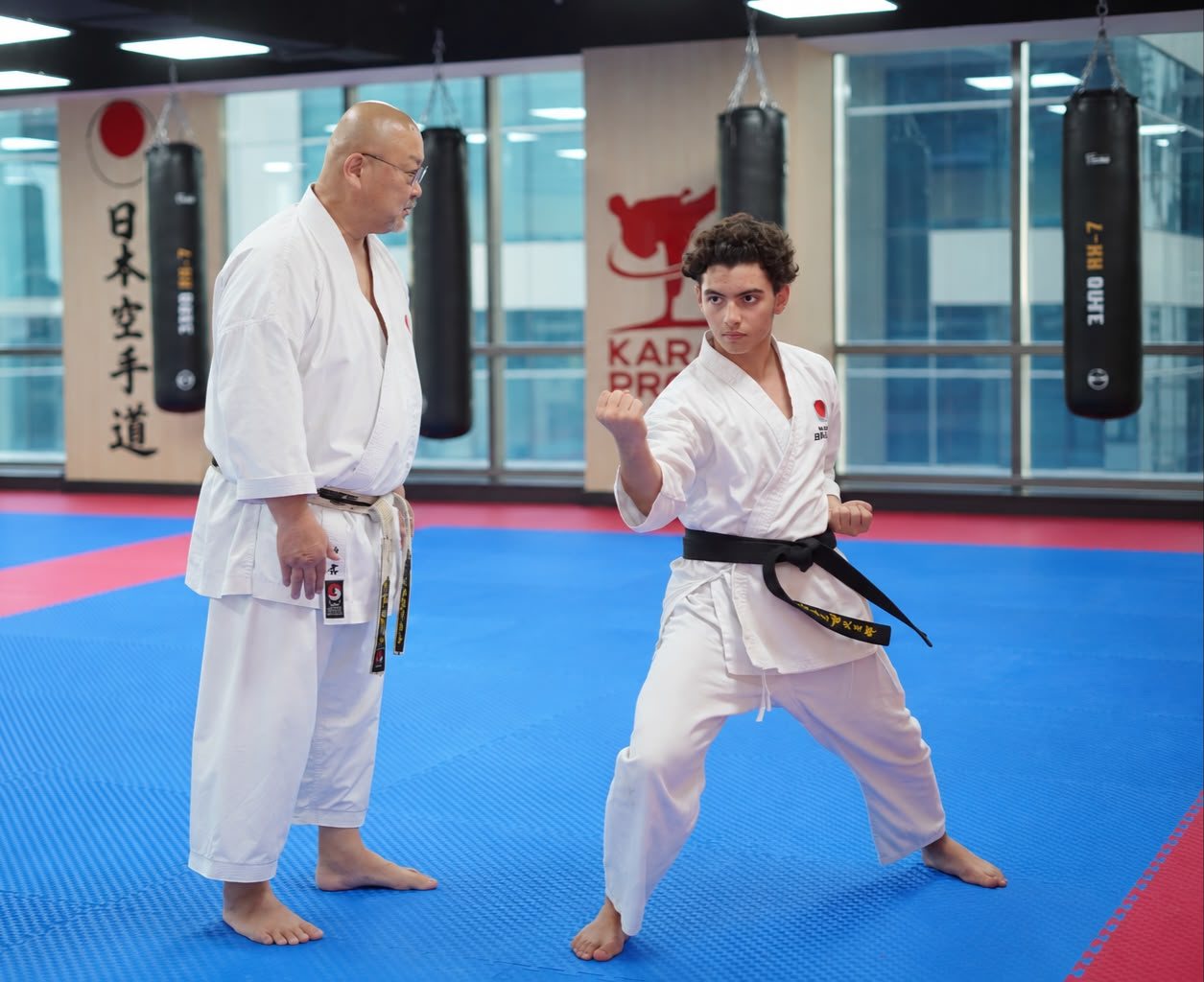A senior instructor coaching a black belt student one-to-one in a private karate session