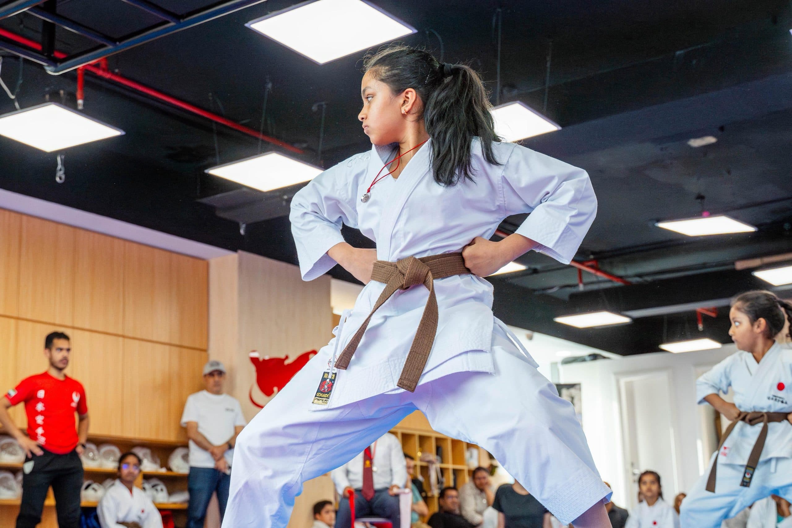 A young student practising a kata stance with individual attention from the instructor